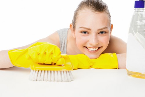 Domestic cleaner wiping kitchen surfaces in a South London home